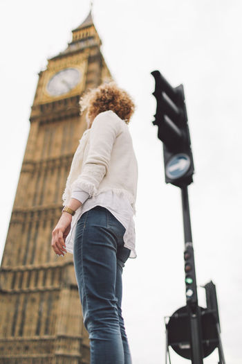 Low angle view of woman against big ben in city