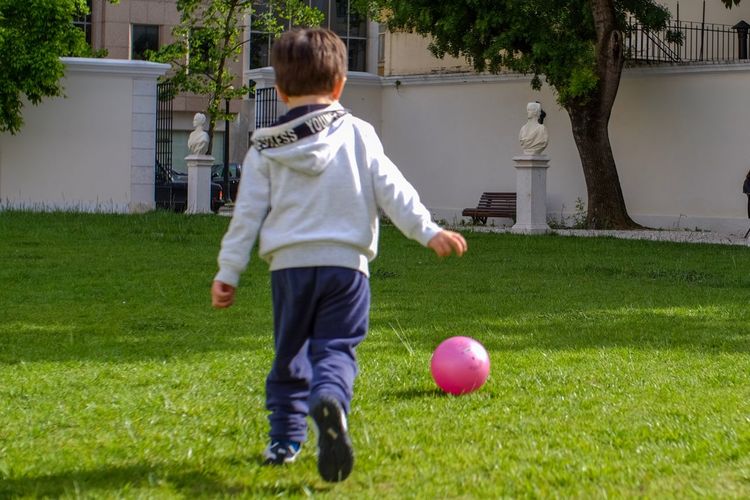 Boy playing with ball on grass