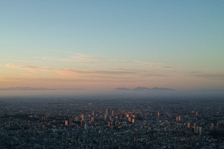 Aerial view of city against sky during sunset