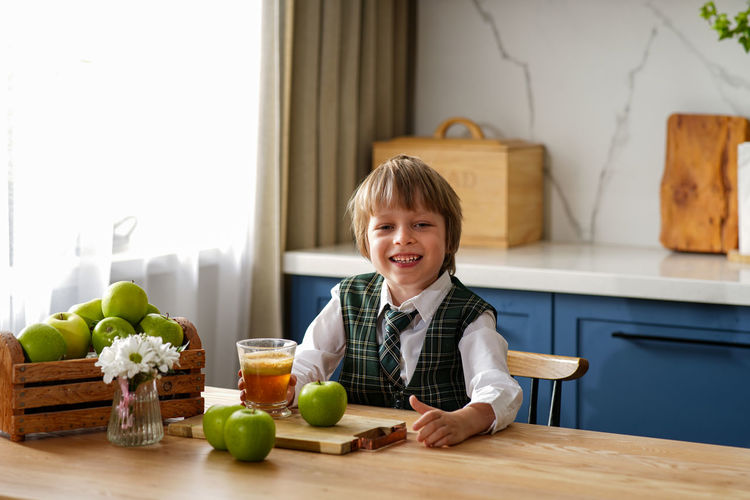 Portrait of smiling boy at table at home
