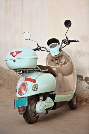 Close-up of scooter standing by wall