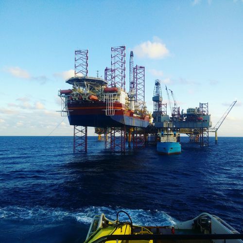Oil platform at sea against sky