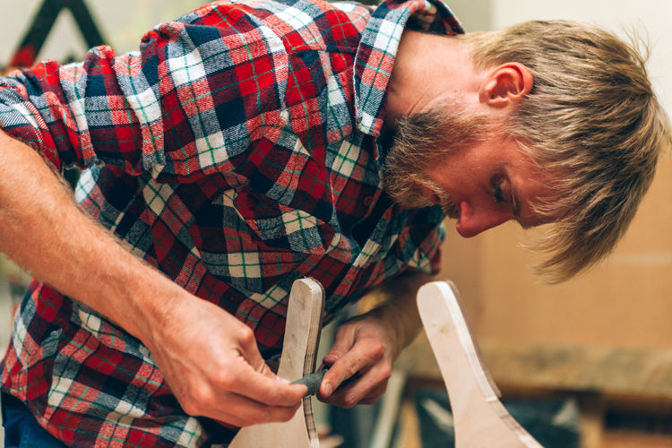 Craftsman working inside carpentry workshop studio using manual lime
