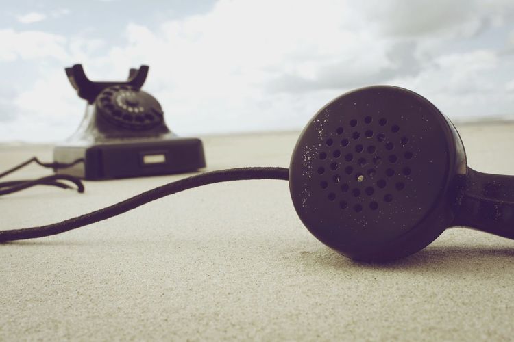Close-up of telephone receiver at beach