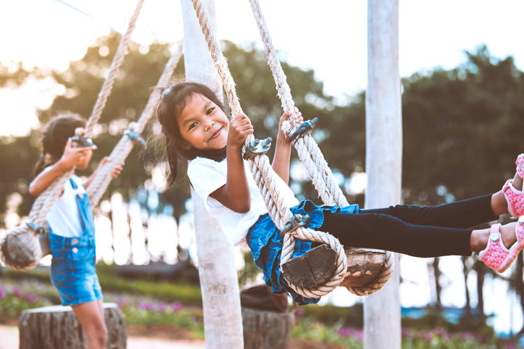 Sisters swinging at playground