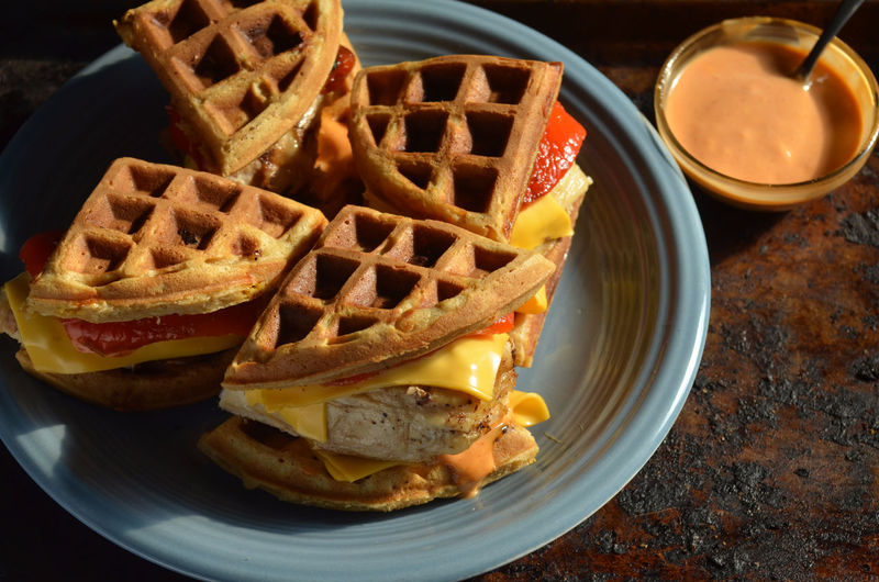 Chicken and savory waffle sandwiches with cheddar cheese, roasted red peppers, aioli sauce