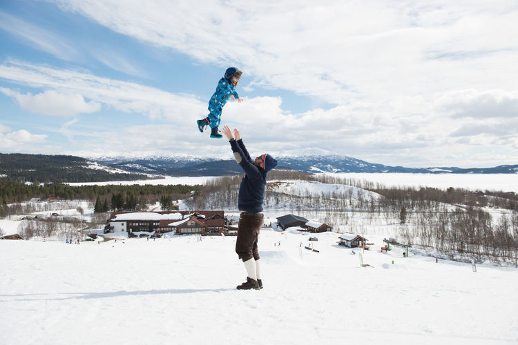 Father son playing in snowy mountain in winter wonderland