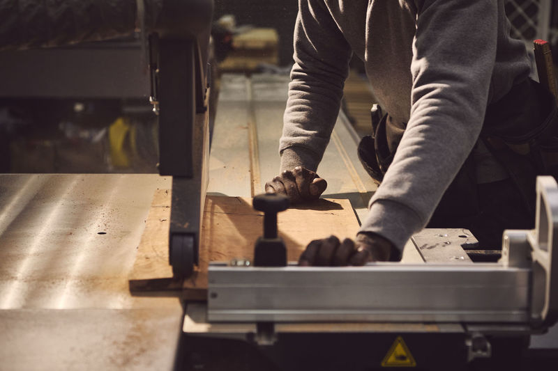 Midsection of carpenter working at workshop