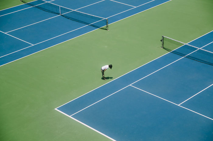 High angle view of woman standing in tennis court