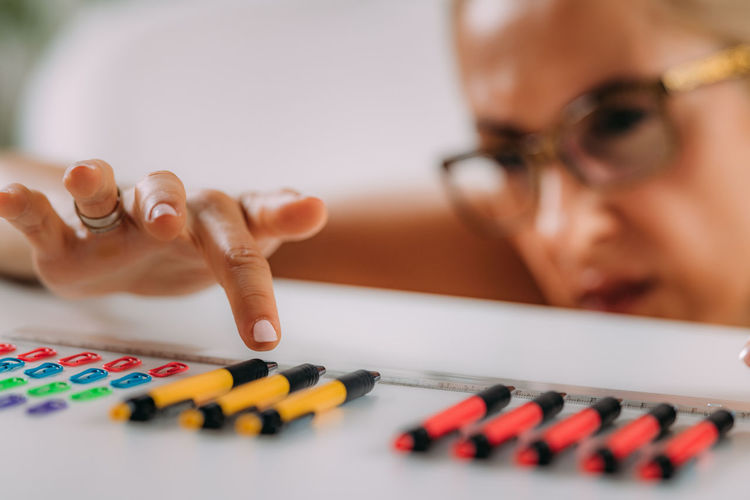 Woman with ocd. obsessive compulsive disorder concept. placing paperclips in a straight line.