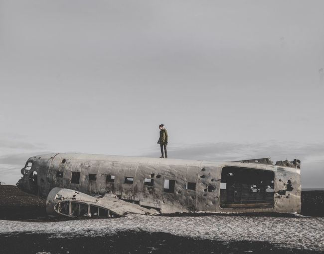 Woman standing on airplane against sky