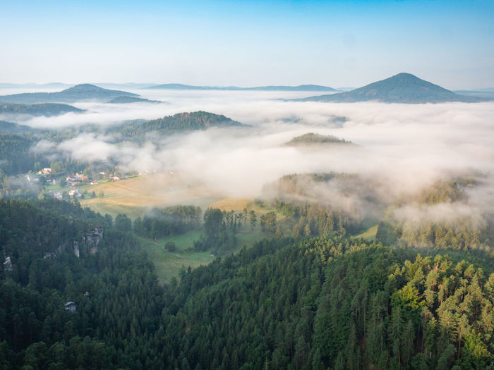 Misty morning in swiss bohemian landscape. jetrichovice village and forest in bohemian switzerland