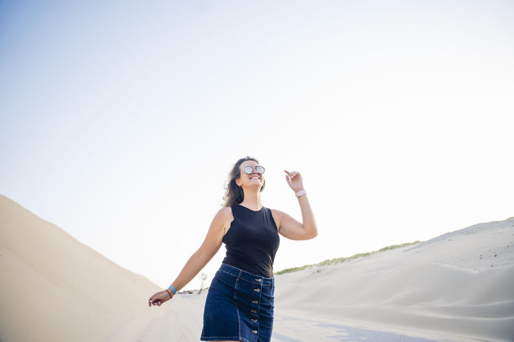 Young woman walking along the dunes