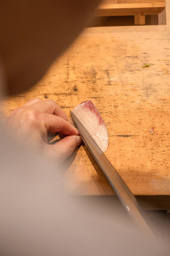 Cropped hand of person cutting board