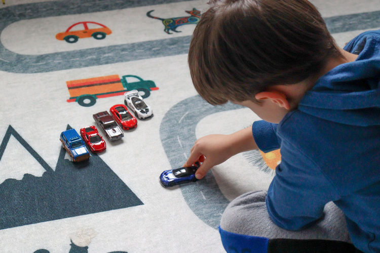 Boy playing toy car on play mat