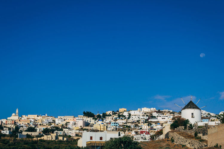 Buildings in town against blue sky