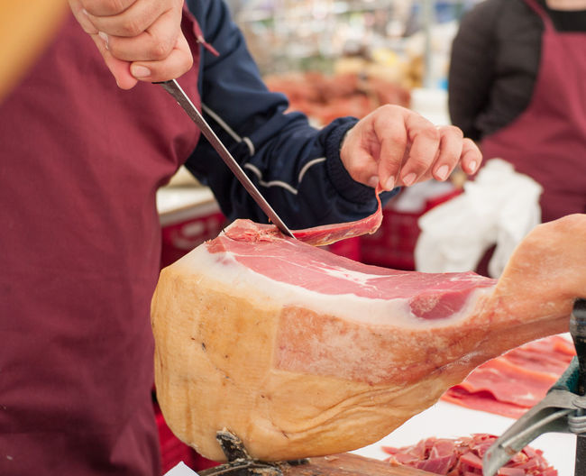 Cropped image of butcher cutting meat at shop