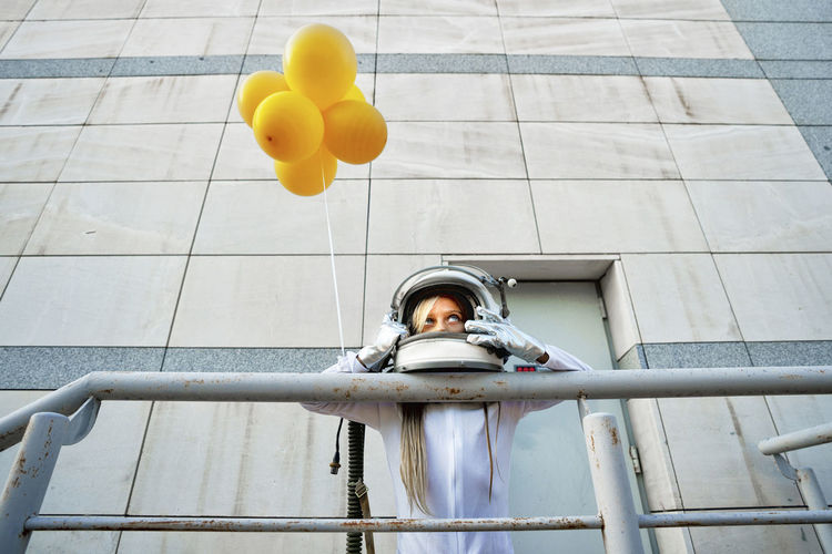 Low angle view of man holding balloons