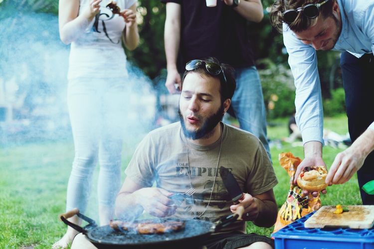 Happy friends enjoying barbecue party at yard