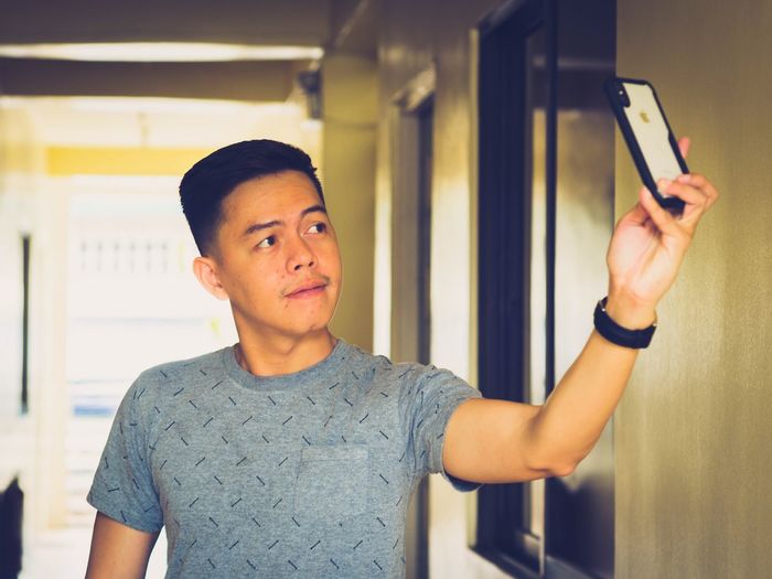 Man taking selfie on mobile phone at home