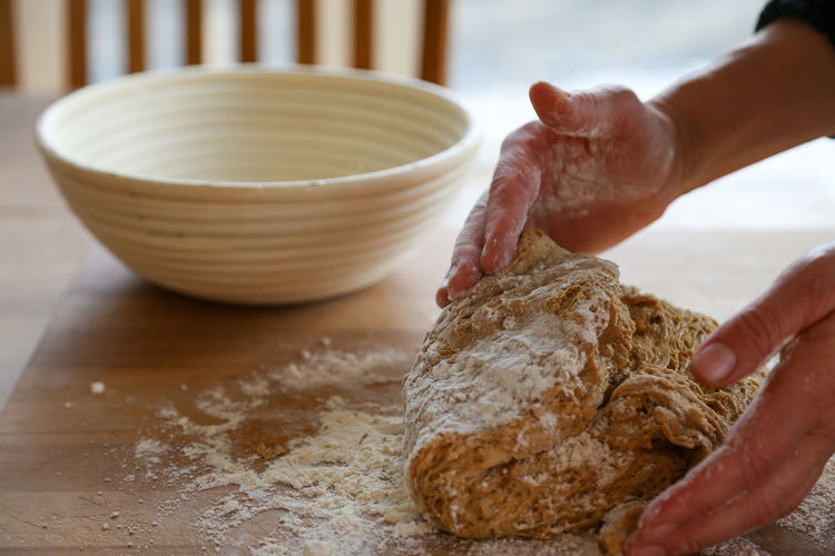 Midsection of person preparing bread dough at home 
