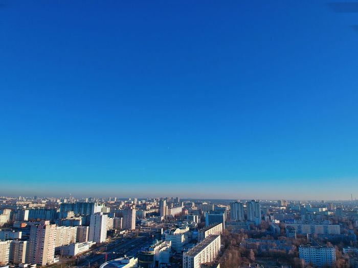 High angle view of buildings against clear blue sky
