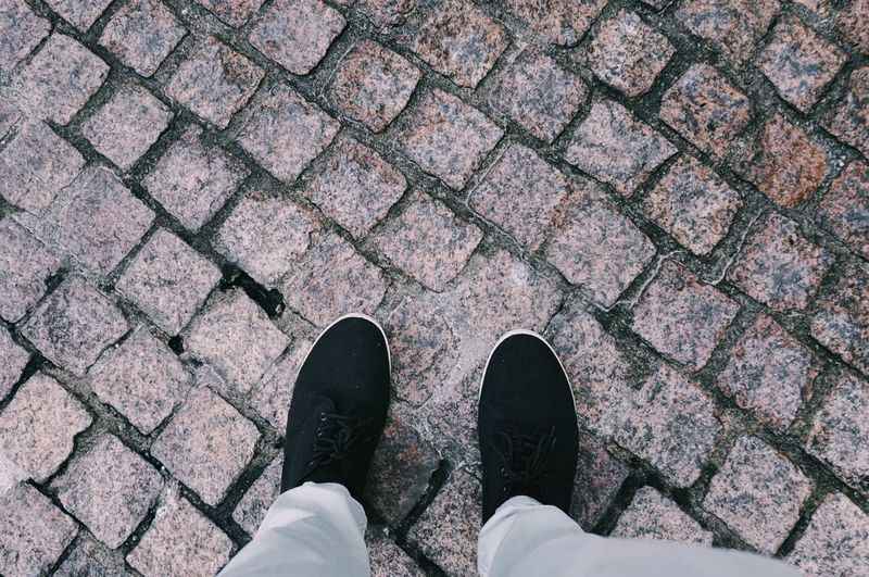 Low section of person standing on cobblestone