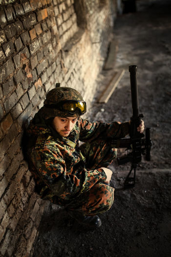 Army soldier standing against wall