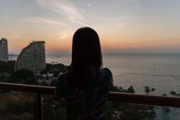An asian woman portrait at the hotel with happiness and sunset time in the pattaya beach, thailand.