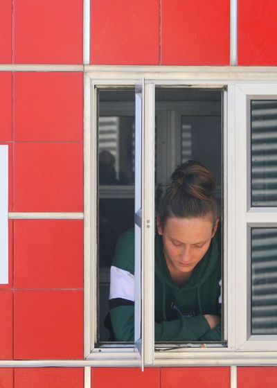 Portrait of woman looking through window