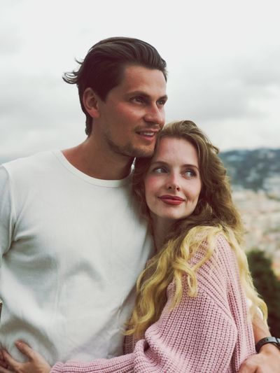 Close-up of couple standing against sky