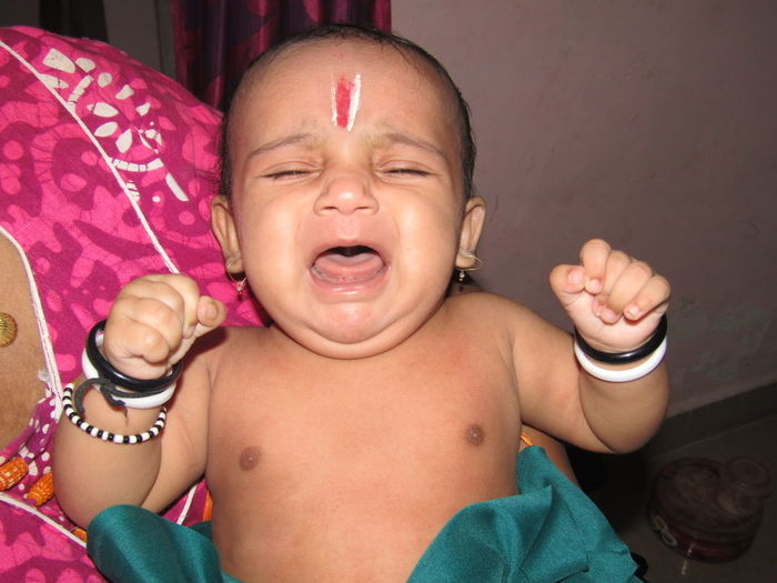 Midsection of mother carrying baby boy during krishna janmashtami at home
