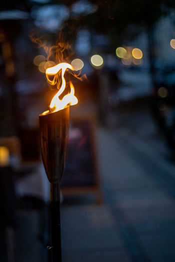 Close-up of lit fire on footpath at night