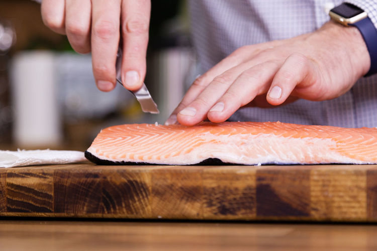 Cropped image of man cleaning fish