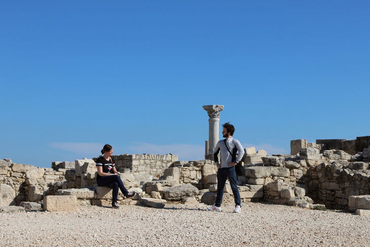Couple looking at eachother against blue sky in limassol, cyprus.