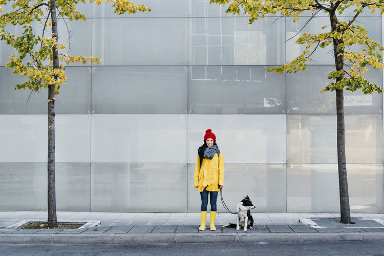 Rear view of woman with dog in city