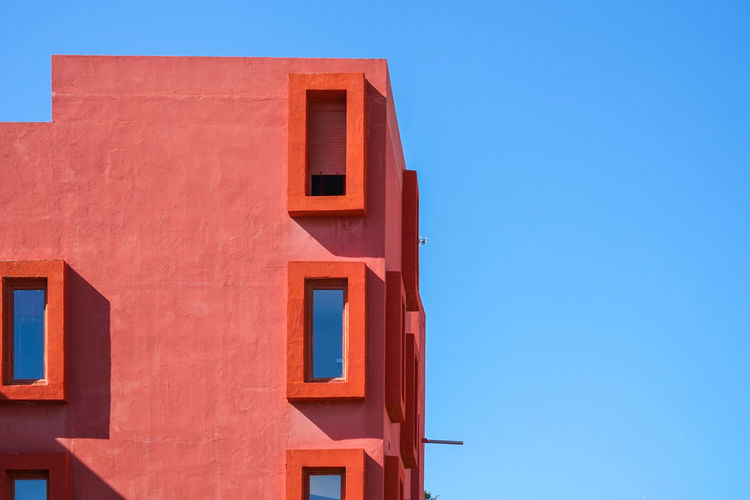 Red modern building in blue sky background. calp, alicante province, spain