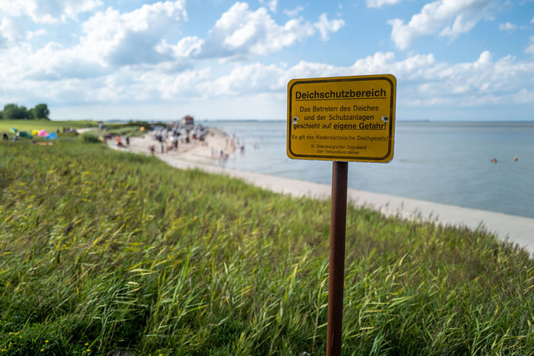 Information sign on land against sky