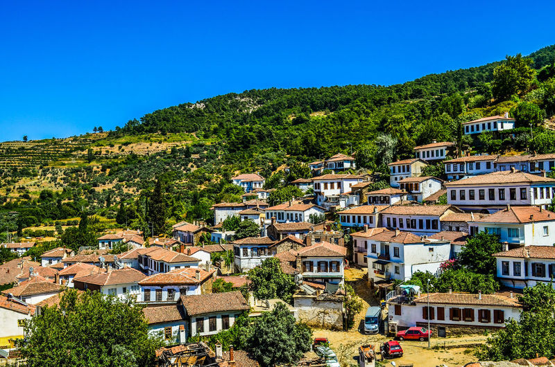 Houses on mountain against clear blue sky