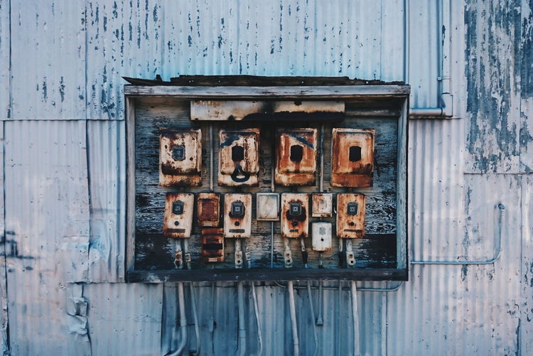 Close-up of electrical boxes on old abandoned building