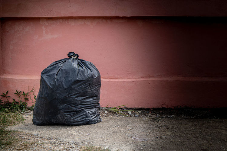 Close-up of garbage bag by wall outdoors