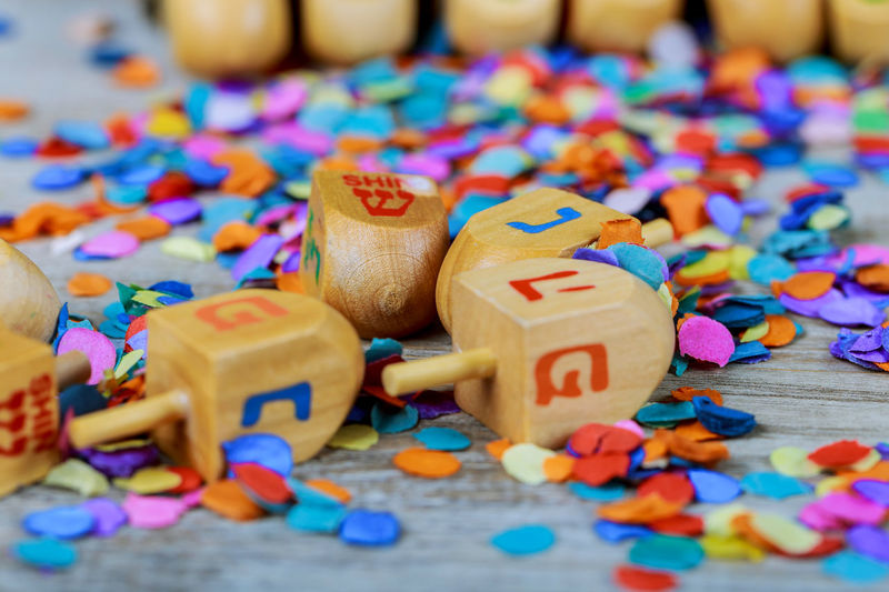 High angle close-up of toy blocks with colorful confetti on wooden table