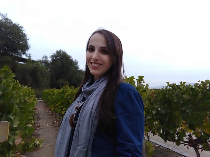 Portrait of smiling young woman standing against sky