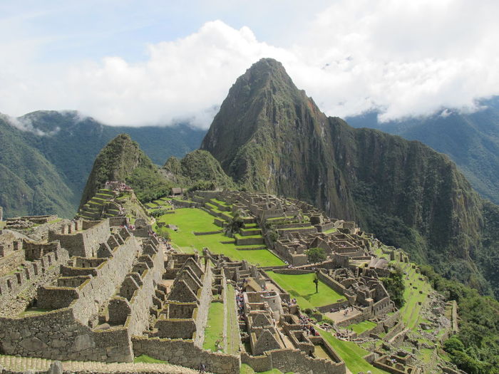 Clear view of machu picchu on a sunny day with thick clouds behind