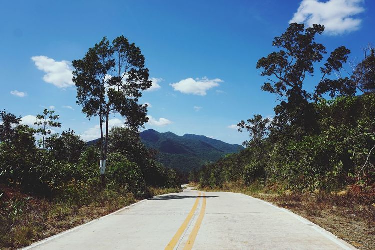 Country road against cloudy sky