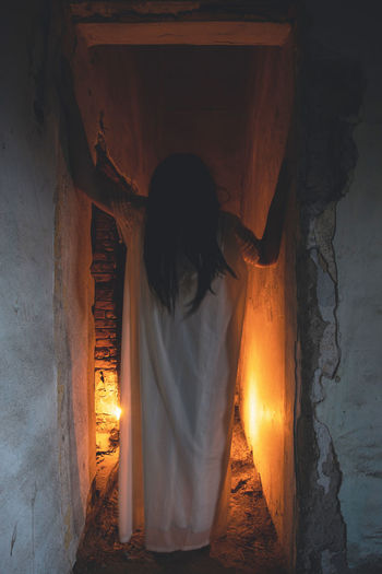 Rear view of woman standing at night