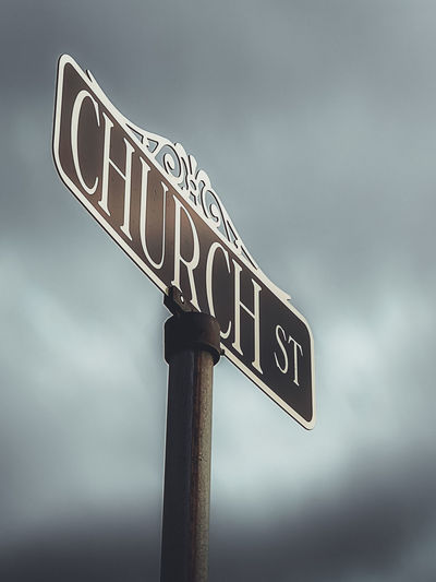 Low angle view of road sign against sky