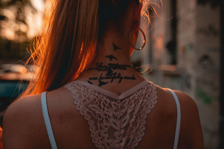 Midsection of woman with tattoo on neck