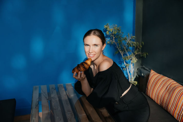 Young woman sitting on sofa at home