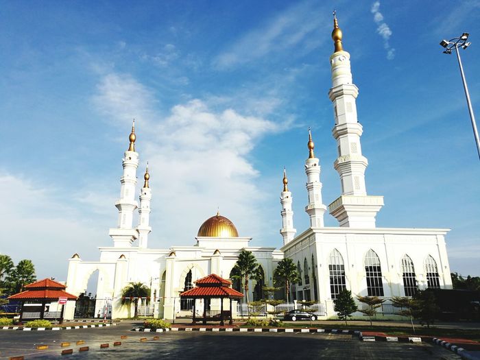 View of mosque against blue sky in city